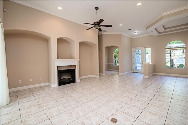 unfurnished living room featuring a tile fireplace, ceiling fan, crown molding, and light tile patterned flooring