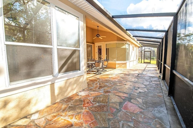 unfurnished sunroom featuring lofted ceiling with beams and ceiling fan