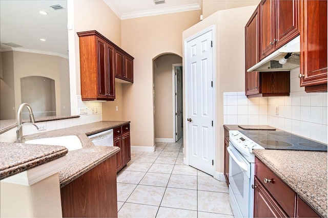 kitchen with white appliances, sink, light tile patterned floors, ornamental molding, and light stone counters