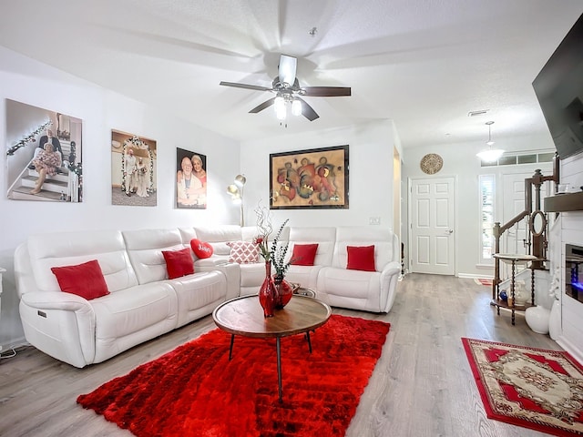 living room featuring stairs, a ceiling fan, and wood finished floors