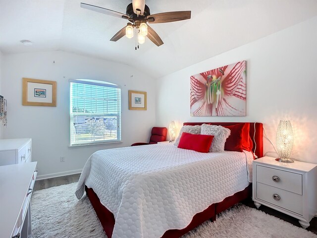 bedroom with a ceiling fan, vaulted ceiling, baseboards, and wood finished floors