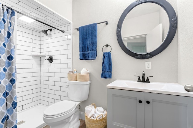 bathroom featuring a shower with shower curtain, vanity, and toilet