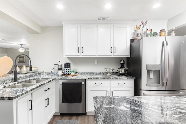 kitchen featuring appliances with stainless steel finishes, ceiling fan, sink, dark stone countertops, and white cabinets