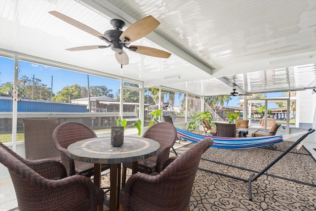 sunroom featuring ceiling fan and plenty of natural light