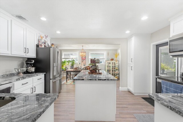 kitchen featuring a center island, white cabinets, and light hardwood / wood-style floors