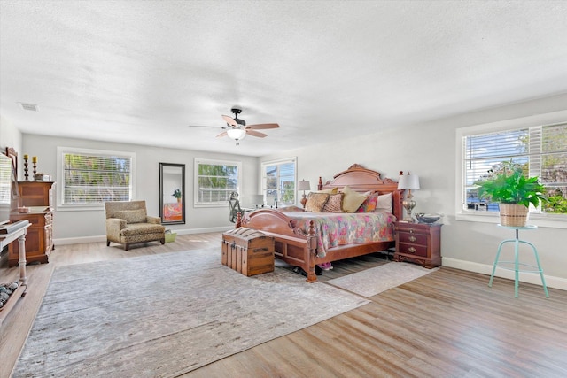 bedroom featuring multiple windows, ceiling fan, and light hardwood / wood-style floors