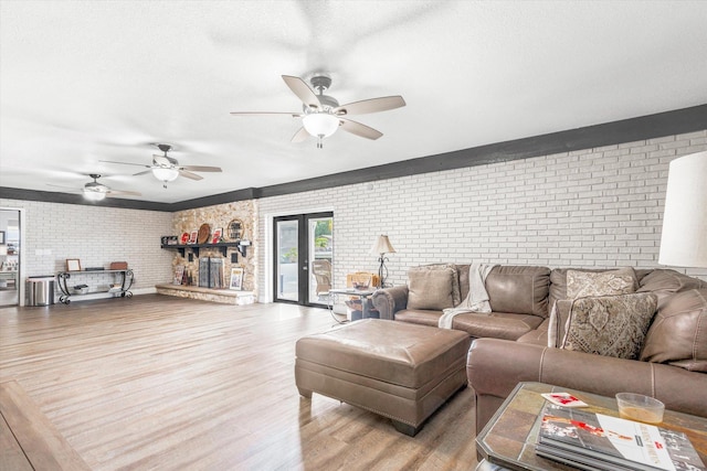 living room with french doors, hardwood / wood-style flooring, and brick wall