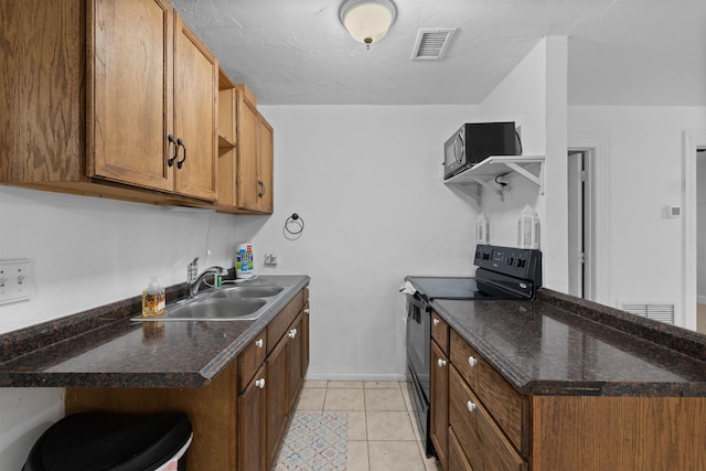 1463 Spring St, Saint Augustine, FL 32084 - kitchen featuring black range with electric cooktop, brown cabinets, dark countertops, and light tile patterned floors
