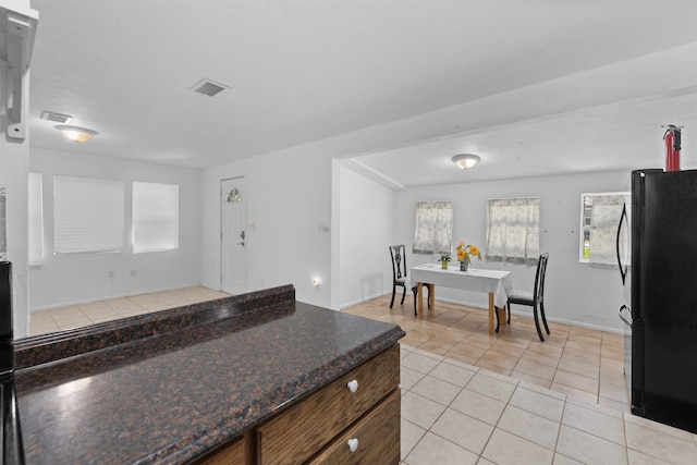 1463 Spring St, Saint Augustine, FL 32084 - kitchen with freestanding refrigerator, light tile patterned floors, and dark countertops