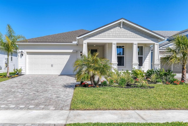 29 Turkey Trot Ct, Saint Augustine, FL 32095 - view of front of home featuring decorative driveway, a front lawn, an attached garage, a porch, and roof with shingles