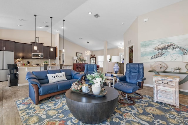 living area with high vaulted ceiling, light wood-type flooring, visible vents, and baseboards