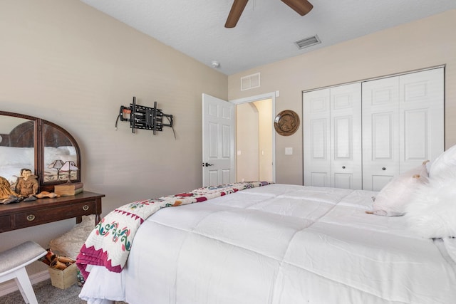 carpeted bedroom with lofted ceiling, a closet, visible vents, and ceiling fan