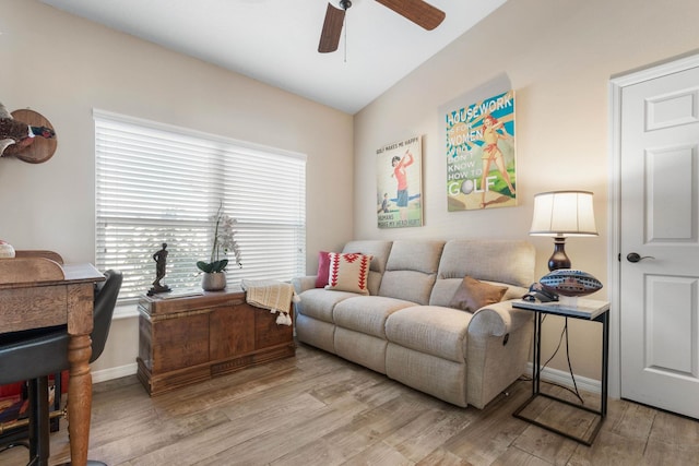 living area with lofted ceiling, light wood-style floors, ceiling fan, and baseboards