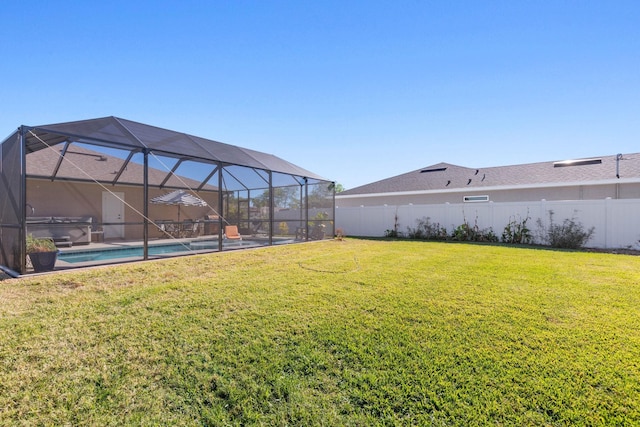 view of yard featuring glass enclosure, a fenced backyard, and an outdoor pool