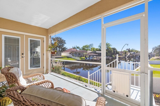 sunroom with a water view and french doors