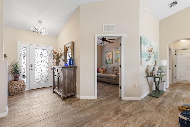 entryway featuring light wood finished floors, visible vents, and arched walkways