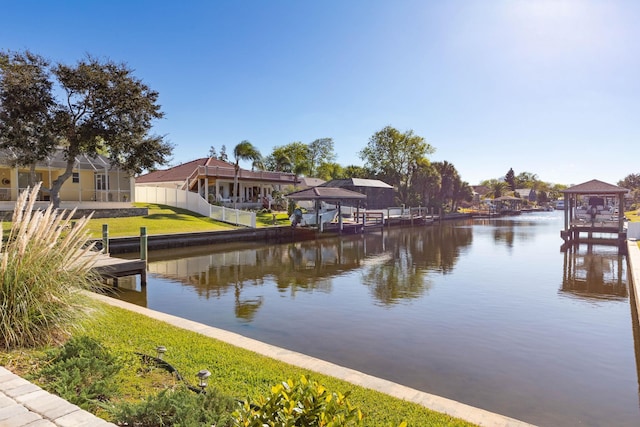 property view of water featuring fence and a boat dock