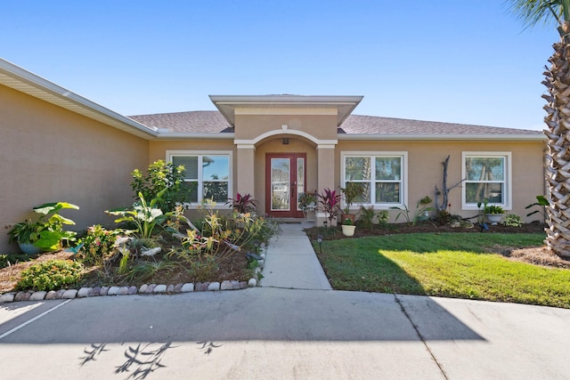 view of front of home featuring a front yard and stucco siding