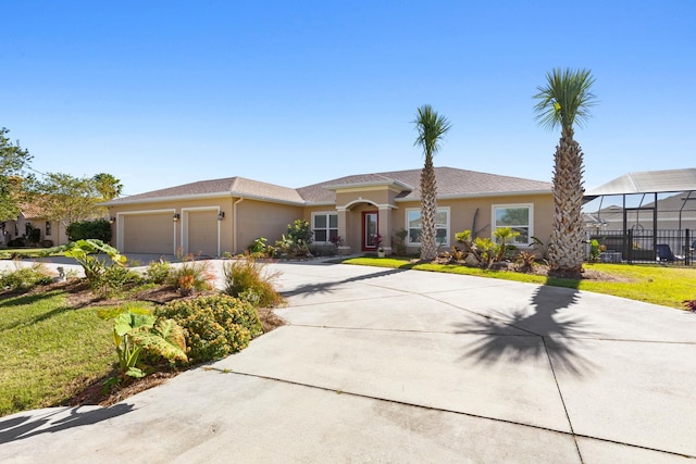 view of front of property with a garage, a front yard, concrete driveway, and stucco siding