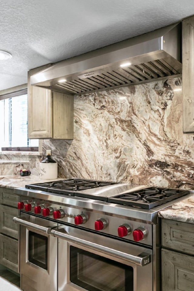 4 Santa Maria Ln, Saint Augustine, FL 32080 - kitchen featuring range with two ovens, wall chimney range hood, backsplash, and a textured ceiling
