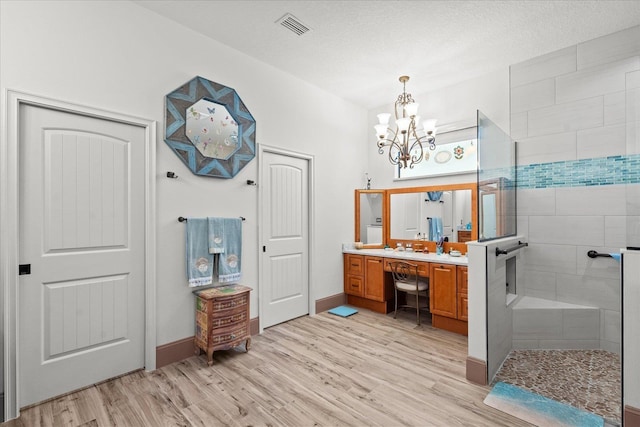 3 Menorca Way, Palm Coast, FL 32137 - bathroom featuring wood finished floors, vanity, a chandelier, and a tile shower