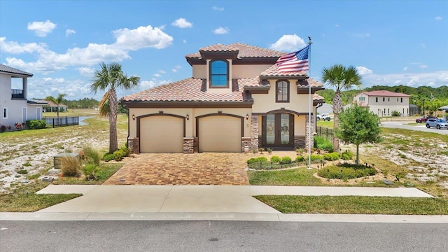 3 Menorca Way, Palm Coast, FL 32137 - mediterranean / spanish-style home featuring stucco siding, driveway, stone siding, a garage, and a tiled roof