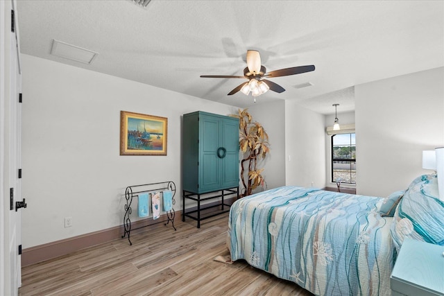 3 Menorca Way, Palm Coast, FL 32137 - bedroom featuring light wood-style floors, attic access, ceiling fan, and a textured ceiling