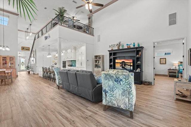 3 Menorca Way, Palm Coast, FL 32137 - living room featuring a towering ceiling, a ceiling fan, and light wood-type flooring