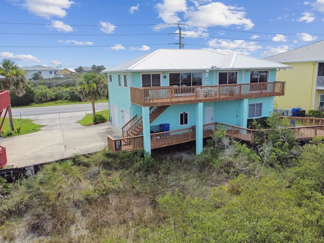8961 A1A, Saint Augustine, FL 32080 - back of house featuring driveway, a garage, stairway, and a metal roof