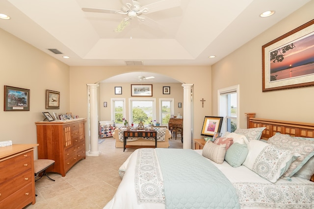 bedroom featuring ornate columns, arched walkways, visible vents, and a tray ceiling
