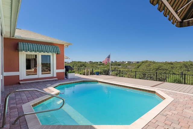 view of swimming pool with fence, a fenced in pool, french doors, and a patio