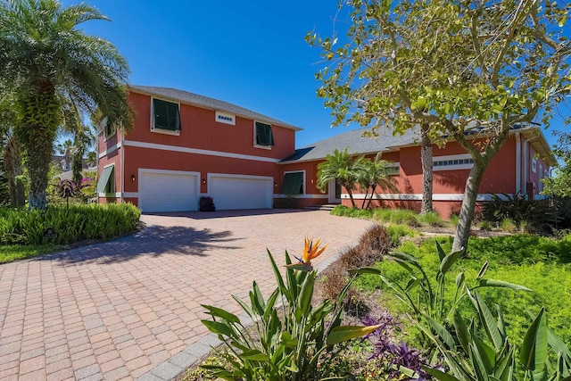 view of front of property with decorative driveway and a garage