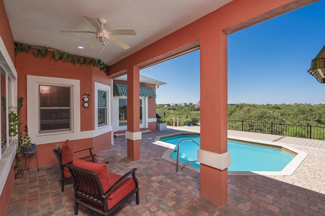 view of swimming pool featuring fence, a ceiling fan, a fenced in pool, and a patio area