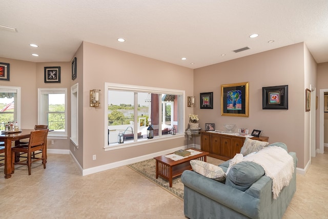 living room featuring baseboards, recessed lighting, light tile patterned flooring, and visible vents