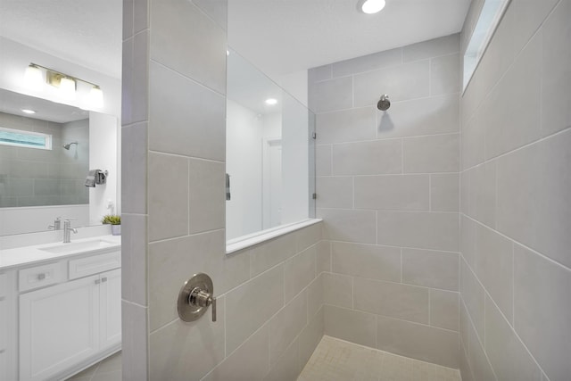 bathroom with vanity and tiled shower