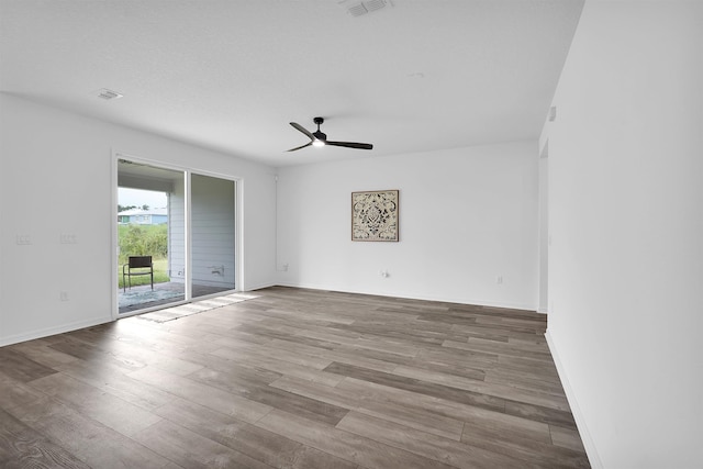 spare room with hardwood / wood-style floors, ceiling fan, and a textured ceiling