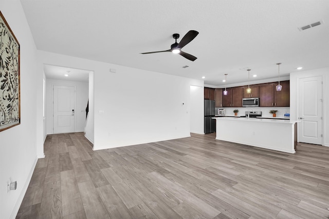 unfurnished living room featuring ceiling fan and light hardwood / wood-style flooring