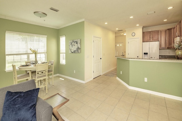 kitchen featuring crown molding, white fridge with ice dispenser, and light tile patterned flooring