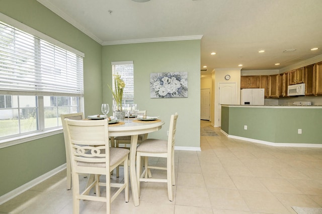 dining space featuring ornamental molding and light tile patterned flooring