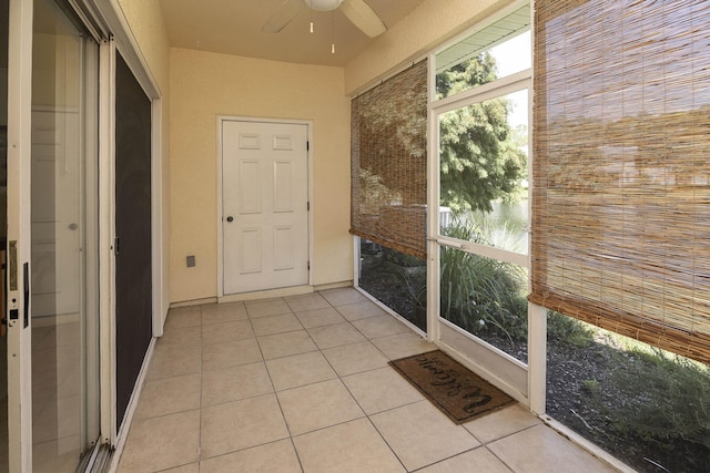 unfurnished sunroom with ceiling fan