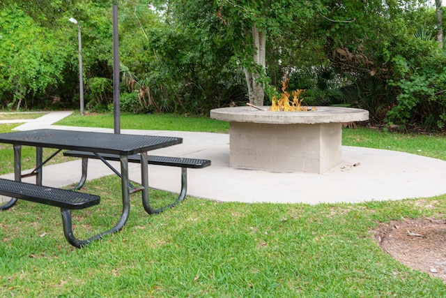 surrounding community with an outdoor fire pit, a lawn, and a patio