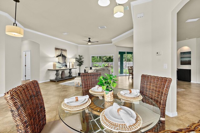 tiled dining room with ceiling fan and ornamental molding