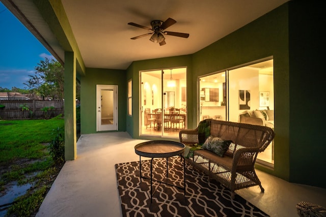 patio terrace at dusk featuring outdoor lounge area and ceiling fan