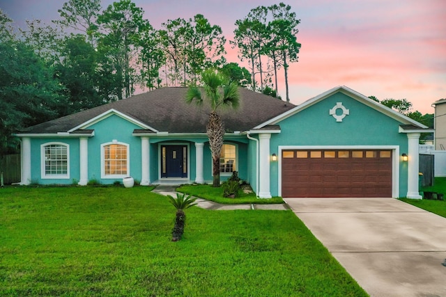 single story home with a lawn and a garage