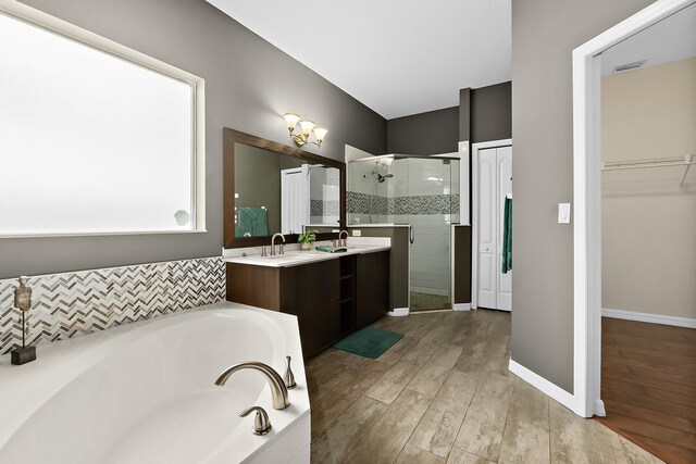 bathroom featuring hardwood / wood-style floors, vanity, and separate shower and tub