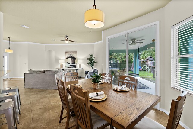 tiled dining space with plenty of natural light and crown molding