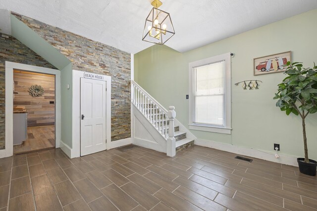 kitchen with sink, hanging light fixtures, stainless steel gas stove, light wood-type flooring, and white cabinetry