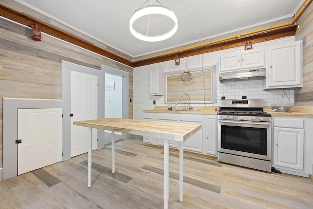 kitchen featuring white cabinets, light wood-type flooring, stainless steel stove, and sink