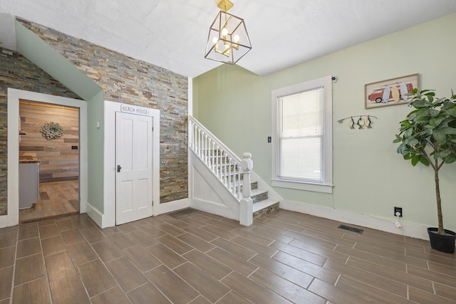 foyer entrance featuring a textured ceiling and a notable chandelier