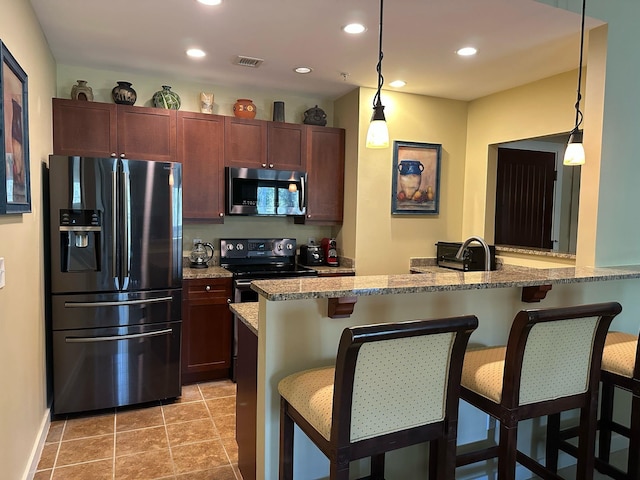 kitchen featuring a breakfast bar area, visible vents, recessed lighting, black appliances, and decorative light fixtures